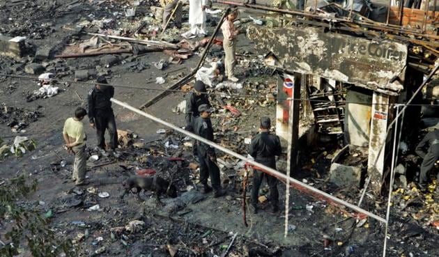 National Security Guard personnel, in black, investigate the site of a blast in Sarojini Nagar area of New Delhi.(AP Photo)