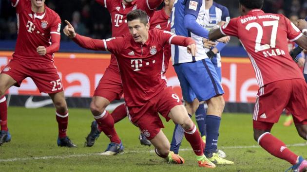 Bayern Munich players celebrate Robert Lewandowski's goal against Hertha Berlin in their Bundesliga match on Saturday.(REUTERS)