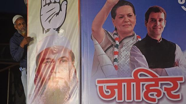 A man cleans a banner at the Congress rally. (Pratik Chorge/HT PHOTO) 