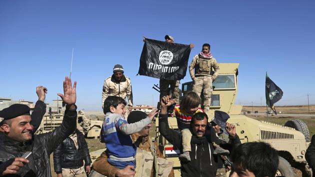 Iraqi army soldiers celebrate with residents of liberated neighbourhoods as they hold upside down a flag of the Islamic State group, in the eastern side of Mosul, Iraq. (AP File Photo) Iraqi army soldiers celebrate with residents of liberated neighbourhoods as they hold upside down a flag of the Islamic State group, in the eastern side of Mosul, Iraq. (AP File Photo)
