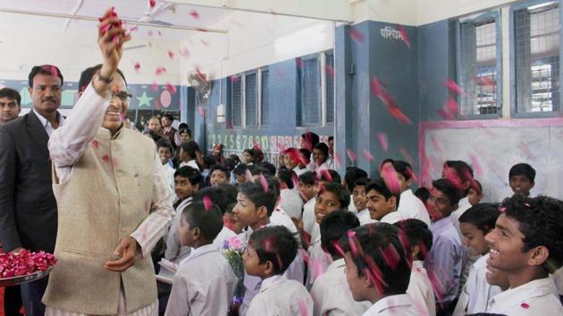 Madhya Pradesh chief minister Shivraj Singh Chouhan showering flower petals on students during the mass teaching event 'Mil- Banchey Madhya Pradesh' during his visit at his Alma Mater Government Sanjay Gandhi Middle School in Bhopal on Saturday. Madhya Pradesh agriculture minister Gauri Shankar Bisen asked questions on the BJP to elementary school children as part of this programme. (PTI) Madhya Pradesh chief minister Shivraj Singh Chouhan showering flower petals on students during the mass teaching event 'Mil- Banchey Madhya Pradesh' during his visit at his Alma Mater Government Sanjay Gandhi Middle School in Bhopal on Saturday. Madhya Pradesh agriculture minister Gauri Shankar Bisen asked questions on the BJP to elementary school children as part of this programme. (PTI)