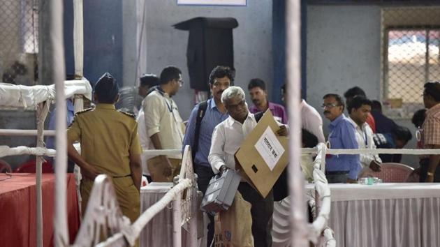 CAN’T TAKE EYES OFF: Polling officials get EVMs at Ghatkopar on Monday. (ARIJIT SEN/HT)