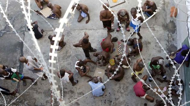 Prisoners play dominoes, checkers or card games, during recreation time inside the National Penitentiary in downtown Port-au-Prince, Haiti. Inmates, some waiting up to eight years to see a judge, try to keep their sanity by maintaining a daily routine of push-ups and lifting jugs filled with dirty water. (Dieu Nalio Chery/AP)