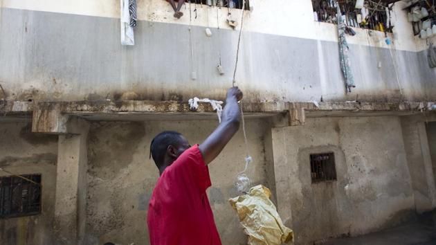 A prisoner puts food in a bag to send up to a fellow inmate. Prison authorities say they try their best to meet inmates' needs, but repeatedly receive insufficient funds from the state to buy food and cooking fuel. Some inmates are provided meals by visiting relatives and others are permitted by guards to meet with contacts to bring in food, cigarettes and other things. (Dieu Nalio Chery/AP)