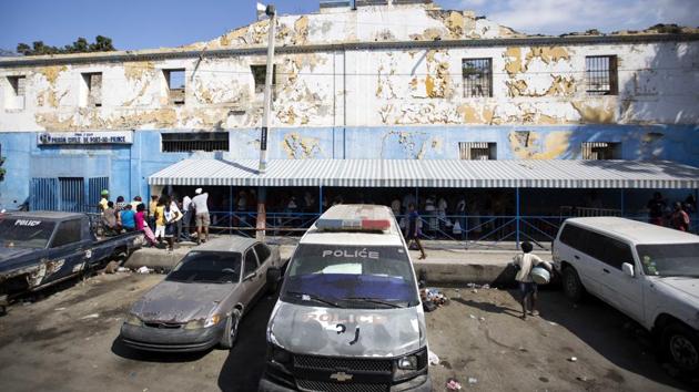 Families with food in tow for their incarcerated relatives, line up in front of the National Penitentiary. Haiti’s penal system is by far the globe’s most congested, with a staggering 454 percent occupancy level, according to the most recent ranking by the University of London's Institute for Criminal Policy Research. (Dieu Nalio Chery/AP)
