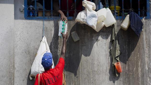 A prisoner sells cigarettes to a fellow inmate. (Dieu Nalio Chery/AP)