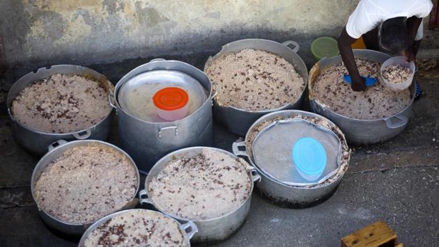 A prisoner fills his lunch bowl with rice and beans. Some foreign officials who have seen the system up close are exasperated by a lack of political will to solve problems of corruption, sluggish justice and prison conditions. (Dieu Nalio Chery/AP)