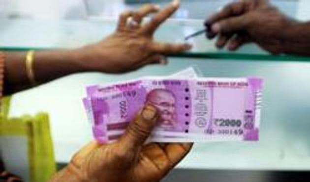 An Indian woman holds Rs 2000 notes as she has her finger marked with indelible ink after depositing old notes, post demonetisation. (AFP) An Indian woman holds Rs 2000 notes as she has her finger marked with indelible ink after depositing old notes, post demonetisation. (AFP)