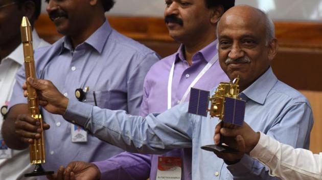 ISRO chairman Kiran Kumar Rao (R) displays models of the CARTOSAT-2 and Polar Satellite Launch Vehicle (PSLV-C37) as he speaks to media after the launch of the Polar Satellite Launch Vehicle (PSLV-C37) at Sriharikota on Febuary 15.(AFP Photo)