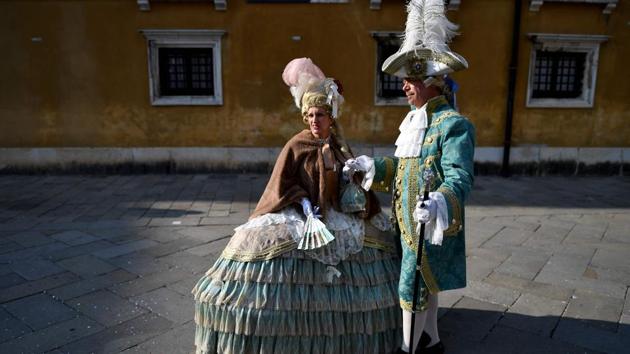 Many don masks and elaborate costumes to join in with the many events taking place across town. (Alberto PIZZOLI / AFP)