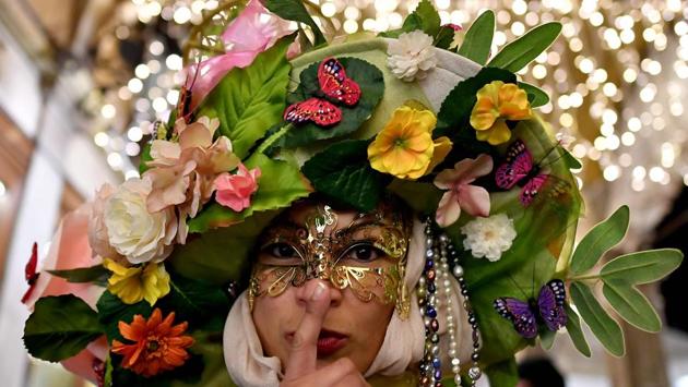 A reveller dressed in masks takes part at the Venice Carnival. (Alberto PIZZOLI / AFP)
