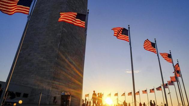 Tourists walk around the base of the Washington Monument on Presidents Day weekend as the sunsets on Sunday in Washington.(AP Photo) Tourists walk around the base of the Washington Monument on Presidents Day weekend as the sunsets on Sunday in Washington.(AP Photo)