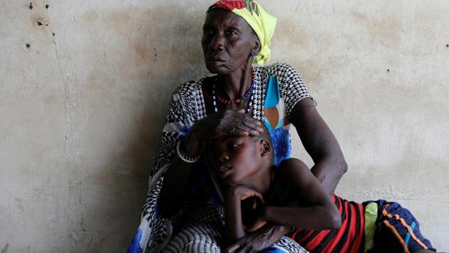 A woman comforts her son, who is suffering from malaria, as they wait for treatment at a Medecins Sans Frontieres run clinic. (Reuters Photo)