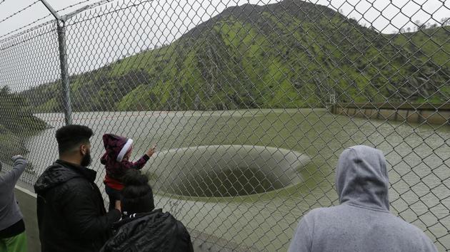 People stop to watch water flow into the iconic Glory Hole spillway at the Monticello Dam on Monday in Lake Berryessa, Calif. (AP Photo) People stop to watch water flow into the iconic Glory Hole spillway at the Monticello Dam on Monday in Lake Berryessa, Calif. (AP Photo)