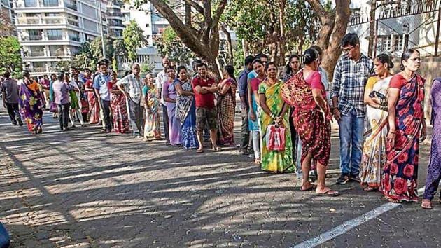 People wait outside a polling booth at juhu on Tuesday.(Satish Bate/HT)