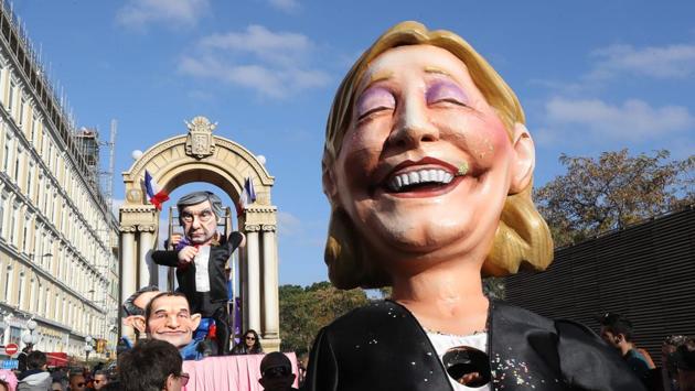 A float depicting French presidential election candidate for the far-right Front National (FN) party Marine Le Pen (R), candidate for the left-wing French Socialist (PS) party Benoit Hamon and candidate for the right-wing Les Republicains (LR) party Francois Fillon (back) parade in the streets of Nice (VALERY HACHE / AFP)