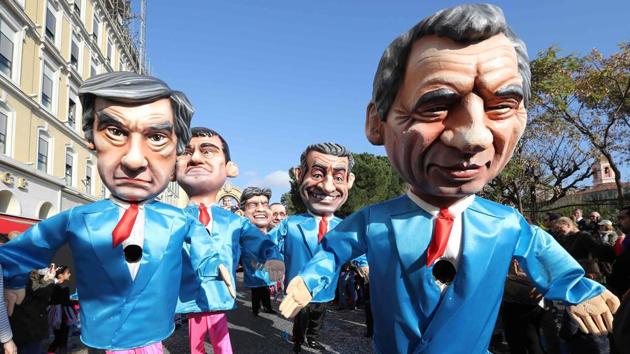 Artists dressed up with costumes depicting French presidential election candidate for the right-wing Les Republicains (LR) party Francois Fillon (L) and president of the center right party Modem Francois Bayrou (R) followed by former Prime Minister Manuel Valls (back,L) and former French president Nicolas Sarkozy in the streets of Nice . (VALERY HACHE / AFP)