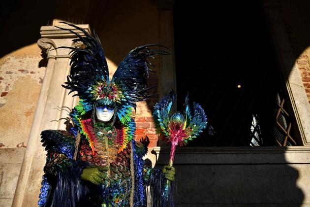 Revellers pose in Saint Mark’s Square during the Venice Carnival. The festival famous for its elaborate masks, is the carnival with the Christian celebration of Lent, forty days before Easter. (Alberto PIZZOLI / AFP)
