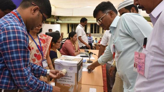 Polling officers open postal ballot boxes as the counting for BMC elections begin, at Global Mill compound in central Mumbai on Thursday.(Anshuman Poyrekar/HT Photo)