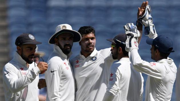 India's Umesh Yadav (C) celebrates with teammates after the dismissal of Australia batsman David Warner.(AFP)