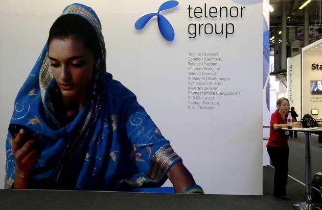 A visitor rests under a Telenor Group sign at the GSMA Mobile World Conference in Barcelona, Spain.(REUTERS)