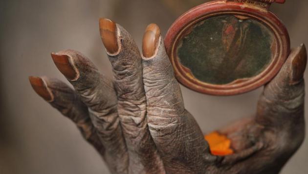 A Hindu holy man holds a mirror as he smears his body with ash and vermillion paste . (Niranjan Shrestha / AP) A Hindu holy man holds a mirror as he smears his body with ash and vermillion paste . (Niranjan Shrestha / AP)