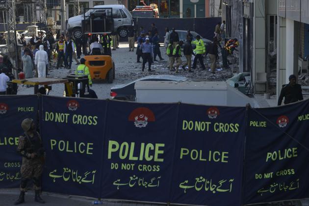 Pakistani security officials examine the site of the attack in Lahore on Wednesday.(AFP)