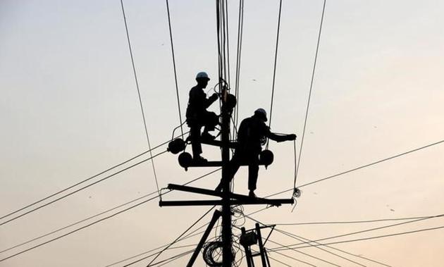 Technicians work on power transmission lines. (Reuters file photo) Technicians work on power transmission lines. (Reuters file photo)