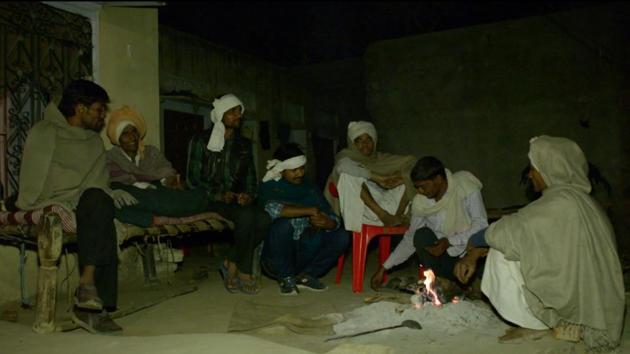 Villagers in Alwar’s Sili Baodi take turn in guarding against a ‘killer’ leopard. In this picture, men sit near a fire at Chhotelal Meena’s house. A leopard is suspected to have killed Meena’s father on Feb 12.(HT Photo)