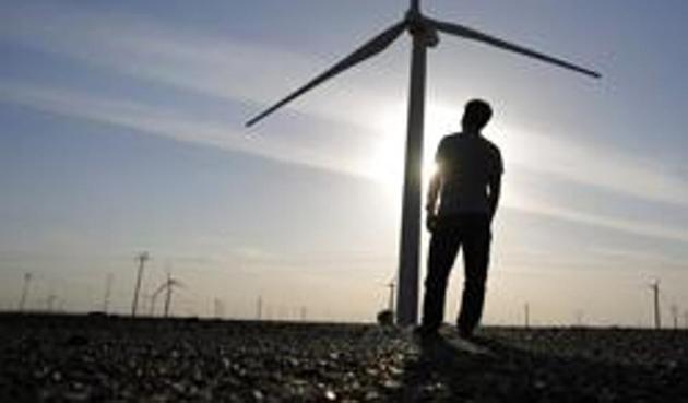 A worker stands in a wind farm in Guazhou, in China.(Reuters)