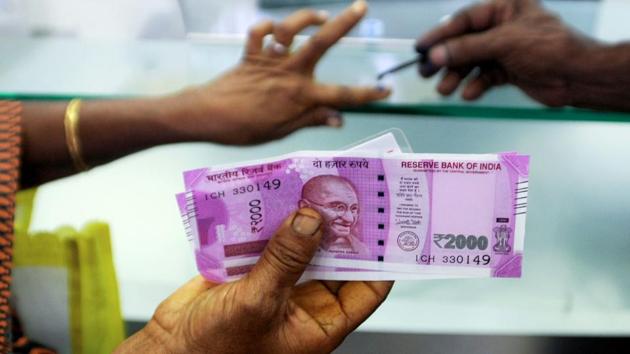 A woman holds Rs 2000 notes as she exchanges demonetised notes at a bank in Chennai. (AFP File Photo) A woman holds Rs 2000 notes as she exchanges demonetised notes at a bank in Chennai. (AFP File Photo)