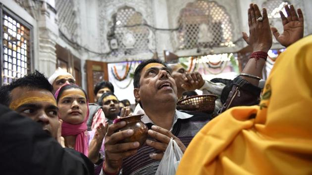 A devotee looks up during morning prayers at a temple. (Saumya Khandelwal/HT PHOTO)