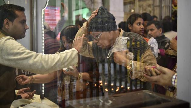 A priest applying tilak on a man’s forehead for good luck. (Saumya Khandelwal/HT PHOTO)