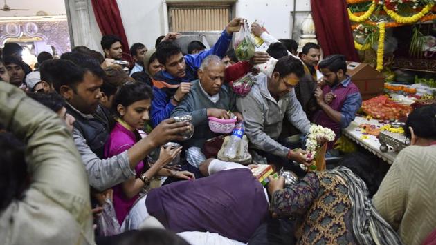 Devotees jostle for space as they offer garlands and prayers below the temple idol. (Saumya Khandelwal/HT PHOTO)
