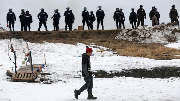 A protester records a video of police officers after evacuating the main opposition camp. (Terray Sylvester/REUTERS)