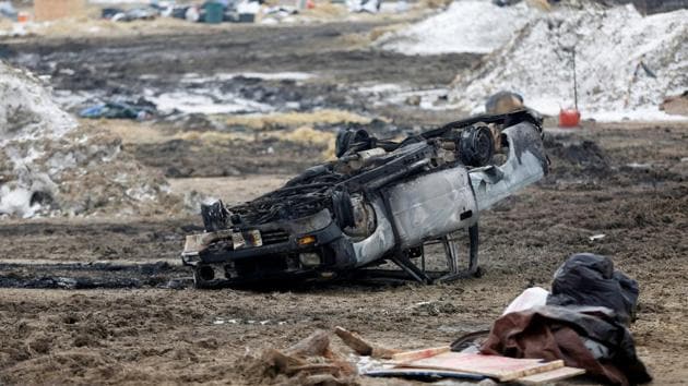 A burned car rests on its roof in the main opposition camp. The state sent a bus to the site on Thursday to transport anyone to Bismarck, where officials were doling out basic necessities, along with hotel and bus vouchers. (Terray Sylvester/REUTERS)