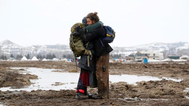 Susanna Travis (left), from Grass Valley, California, embraces Timothy Powers, also from California, before evacuating the opposition camp. (Terray Sylvester/REUTERS)