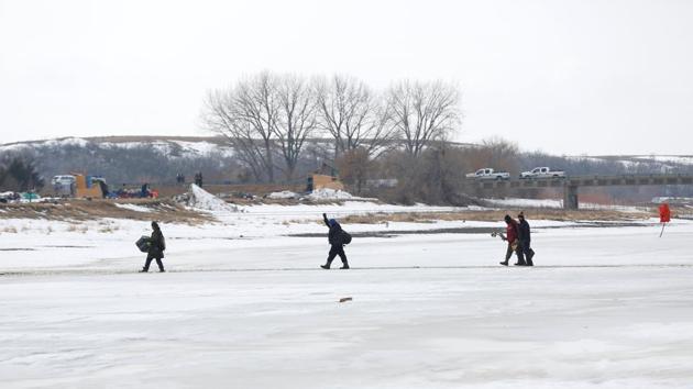 Protesters cross the frozen Cannon Ball River as they evacuate the main opposition camp. Native Americans who oppose the $3.8 billion pipeline established the Oceti Sakowin camp last April on federal land near the Standing Rock Indian Reservation to draw attention to their concerns that the project will hurt the environment and sacred sites - claims Dallas-based pipeline developer Energy Transfer Partners disputes. (Terray Sylvester/REUTERS)