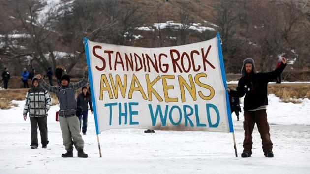 Protesters hold a banner after evacuating the main opposition camp. (Terray Sylvester/REUTERS)
