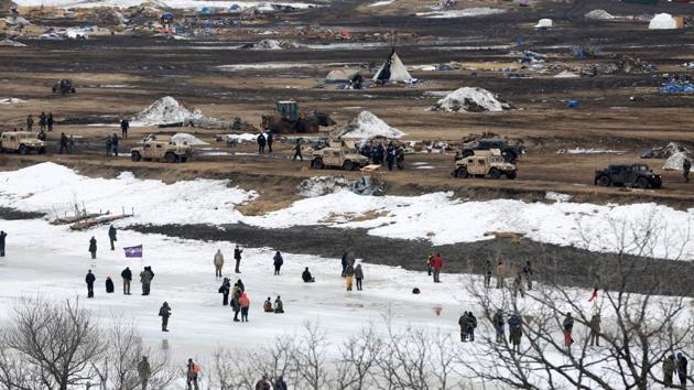 Protesters confront police from the surface of the frozen Cannon Ball River after being driven from the main opposition camp against the Dakota Access oil pipeline. (Terray Sylvester/REUTERS)