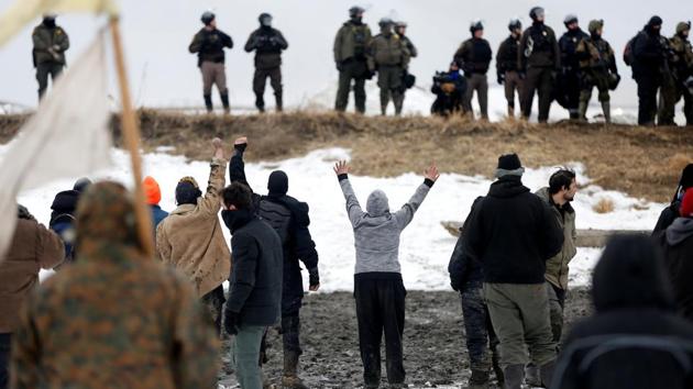 Guardsmen and officers entered the camp from two directions shortly before midday, alongside numerous law enforcement and military vehicles and with a helicopter and airplane overhead. (Terray Sylvester/REUTERS)