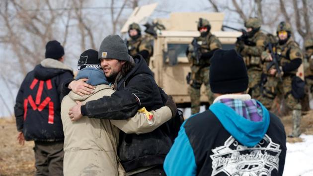 Protesters embrace while evacuating the main opposition camp. The camp gained increased attention starting in August after its population had grown and authorities made their first arrests. (Terray Sylvester/REUTERS)