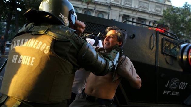 A riot policeman tries to detain a protester during a rally marking the anniversary of the death of union leader Juan Pablo Jimenez, in Santiago, Chile. (Ivan Alvarado/REUTERS) A riot policeman tries to detain a protester during a rally marking the anniversary of the death of union leader Juan Pablo Jimenez, in Santiago, Chile. (Ivan Alvarado/REUTERS)