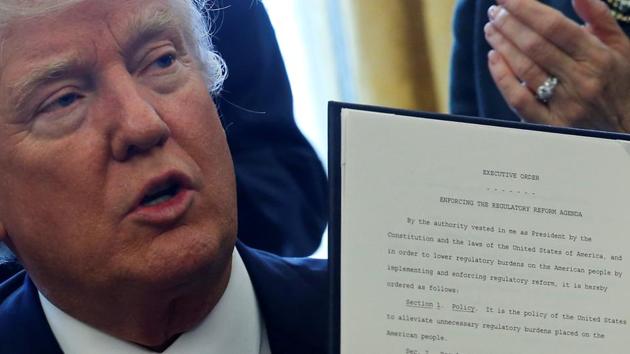 US President Donald Trump is surrounded by business leaders as he signs an executive order on regulatory reform at his desk in the Oval Office at the White House on February 24. (REUTERS) US President Donald Trump is surrounded by business leaders as he signs an executive order on regulatory reform at his desk in the Oval Office at the White House on February 24. (REUTERS)