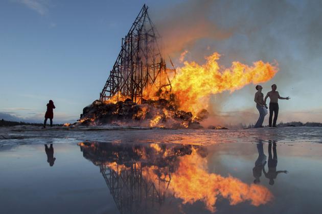 People react as a sculpture is burning at the Maslenitsa festival at the Nikola-Lenivets art park in south-west of Moscow, Russia. (AP)