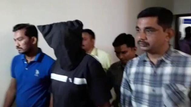 ATS personnel take one of the brothers, accused of having Islamic State links, into custody. (HT Photo) ATS personnel take one of the brothers, accused of having Islamic State links, into custody. (HT Photo)