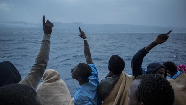 African refugees and migrants celebrate their arrival in Italy . (Santi Palacios / AP)