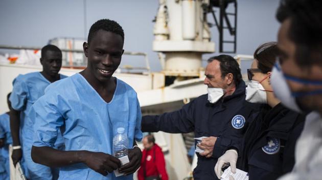 African refugees and migrants disembark, at the Italian port of Reggio Calabria after being rescued off the Libyan coast. (Santi Palacios / AP)