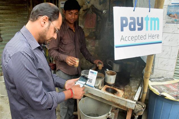 A person pays his bill at a tea stall using Paytm app at Balurghat in South Dinajpur on Saturday.(PTI)