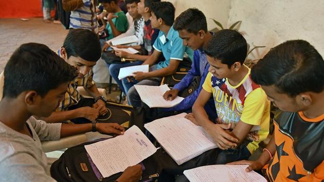 Students do some last-minute studying and compare notes before the paper at a centre in Malad on Tuesday. (Pratham Gokhale/HT PHOTO) 